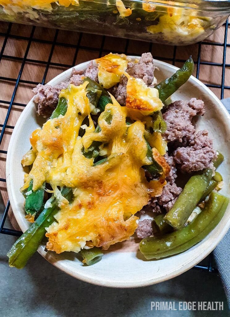 Green bean hamburger casserole on a white plate on a wire rack.