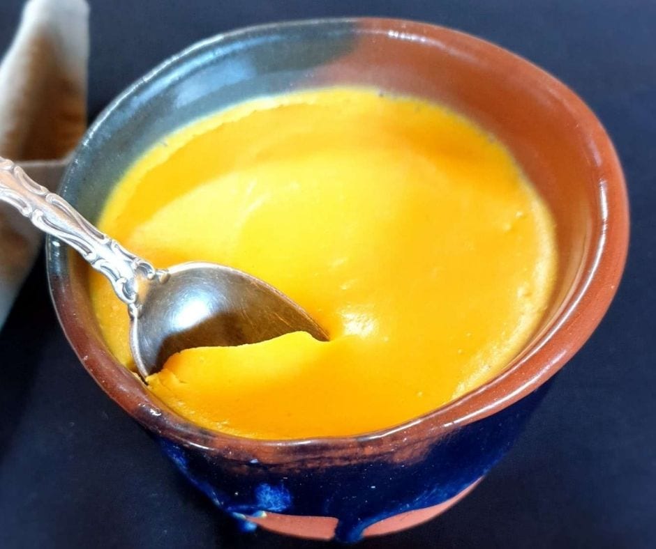 Egg pudding in a cup served with a spoon.