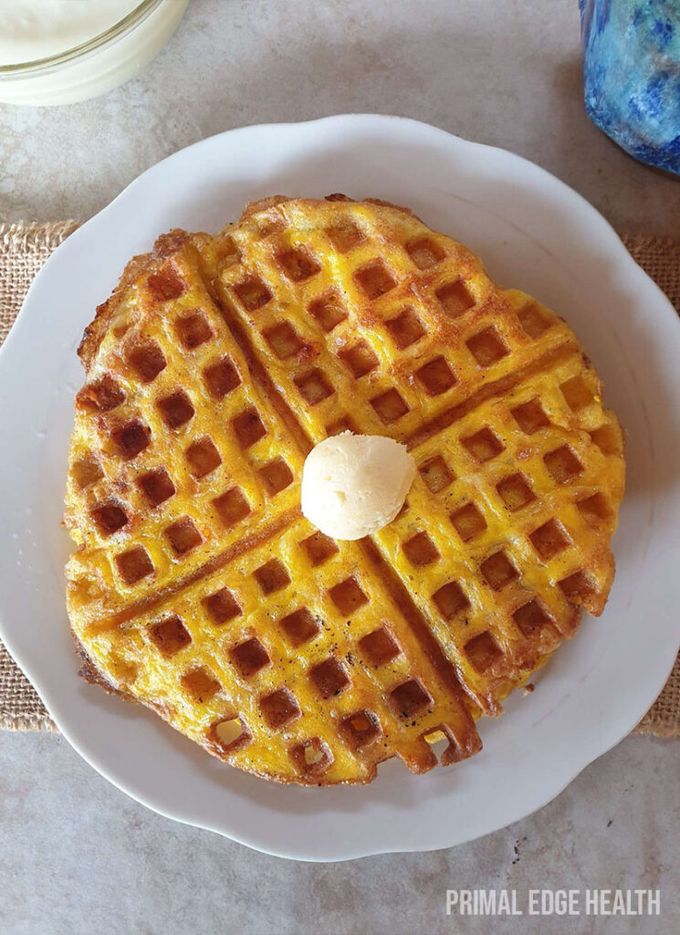 Carnivore waffles on a white plate on a marble surface.
