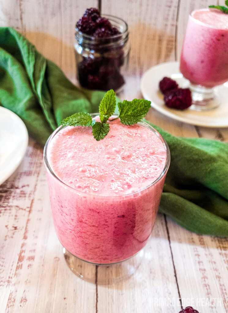 Blackberry smoothie in a glass with garnish.