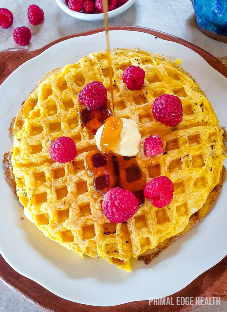 Keto waffles with syrup being poured on top.