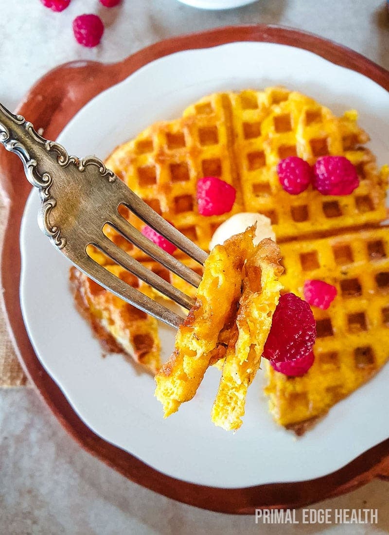 Keto waffles with a fork taking a bite out of it.