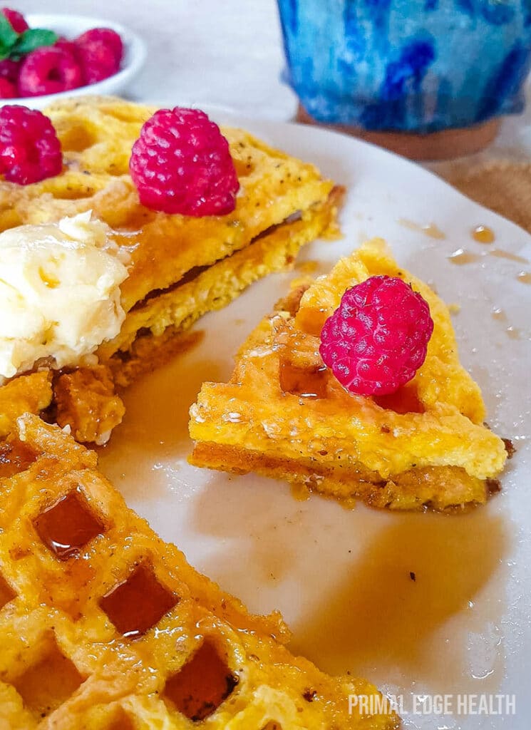 Keto waffle with berries on top on a plate.