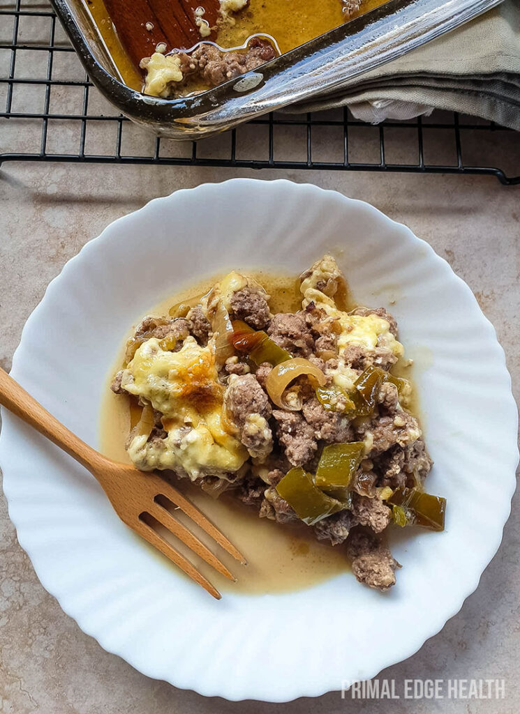 Philly cheesesteak casserole on a plate served with with a wooden fork.