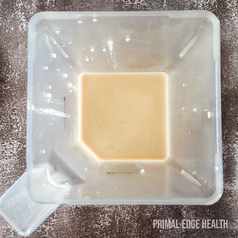 A container of brown liquid on a textured surface.