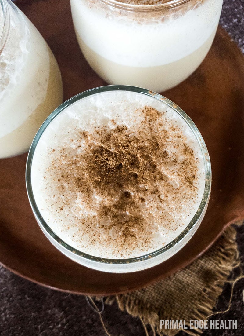 Chai smoothie served in a glass on a wooden board.