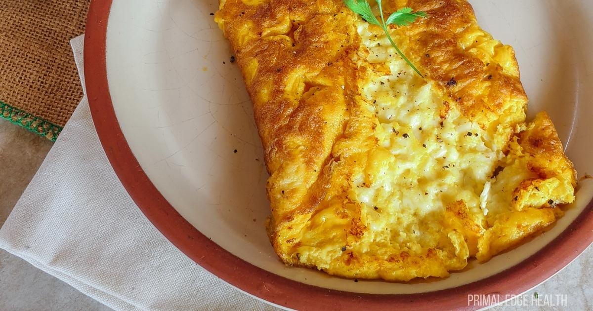 Three cheese omelette on a white plate.