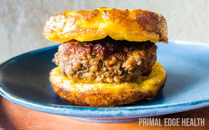 A carnivore burger with a meat patty between two burger buns on a plate.