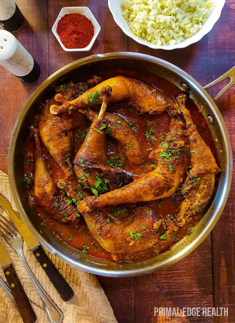 Chicken legs in creamy paprika sauce wooden background.