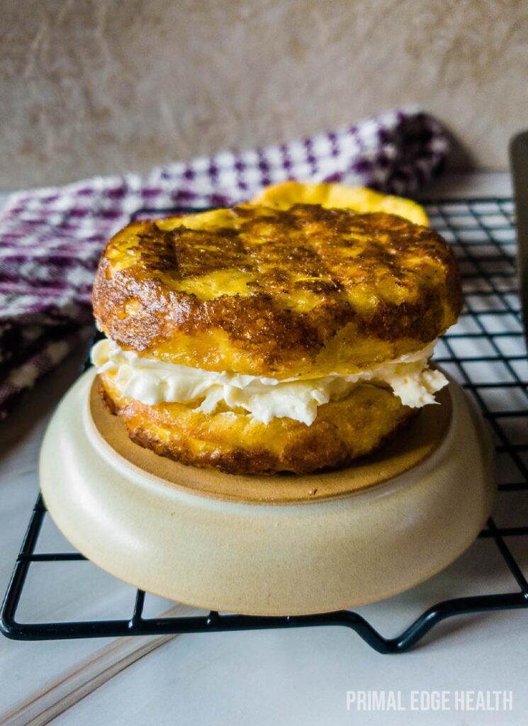 English muffin filled with cream on an upside down plate.
