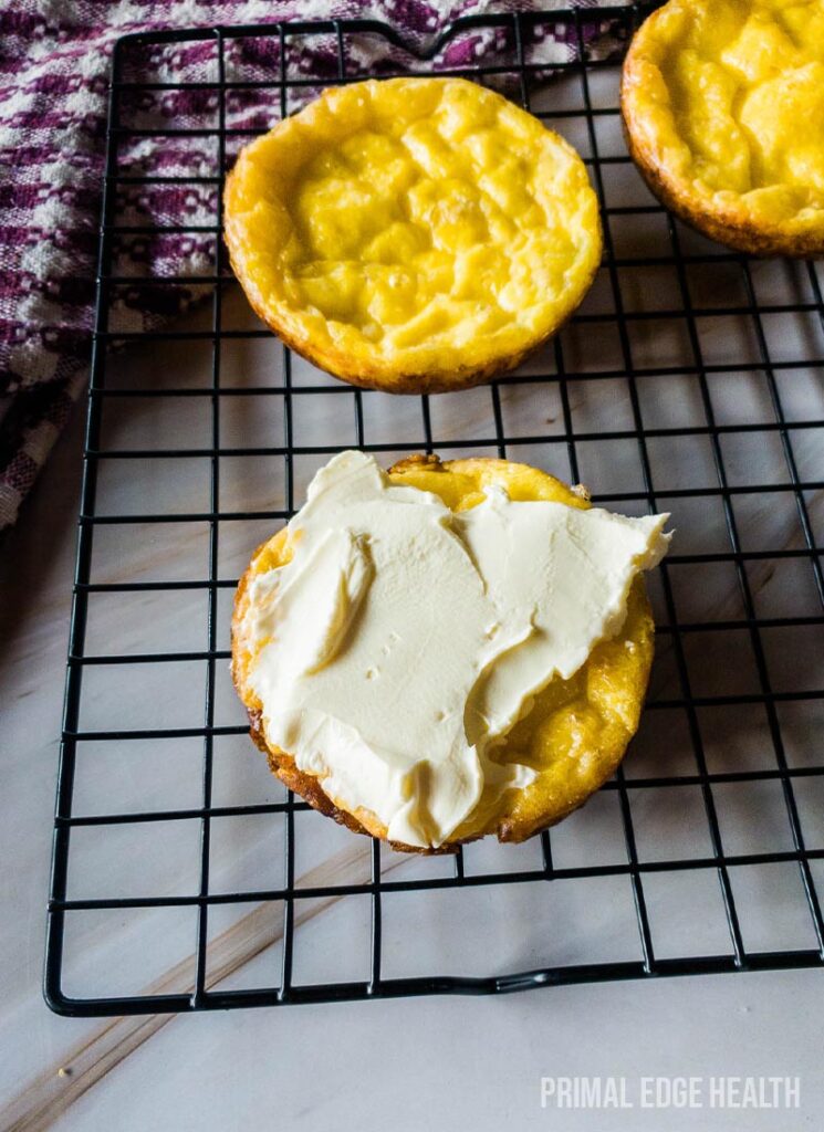 Yellow muffins on a cooling rack.