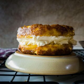 A picutre of an English muffin chaffle with cream cheese on upside down plate.