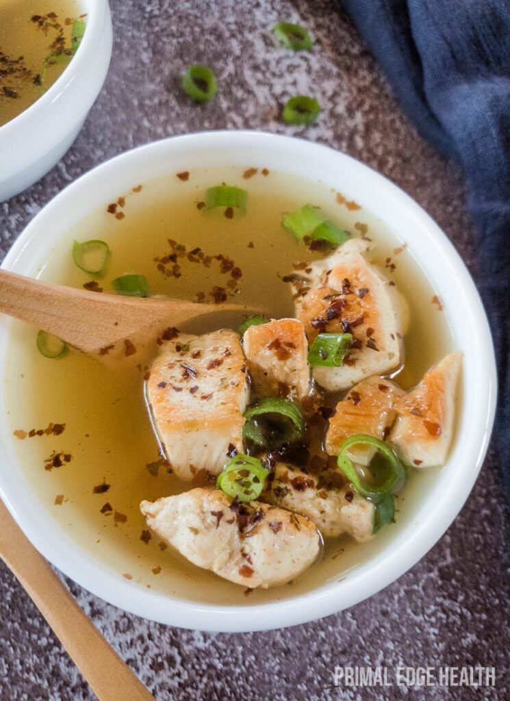 Soup in a white bowl on textured surface.