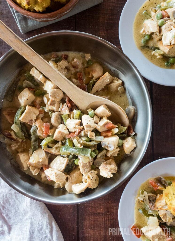 A bowl of keto chicken ala king with a wooden spoon.
