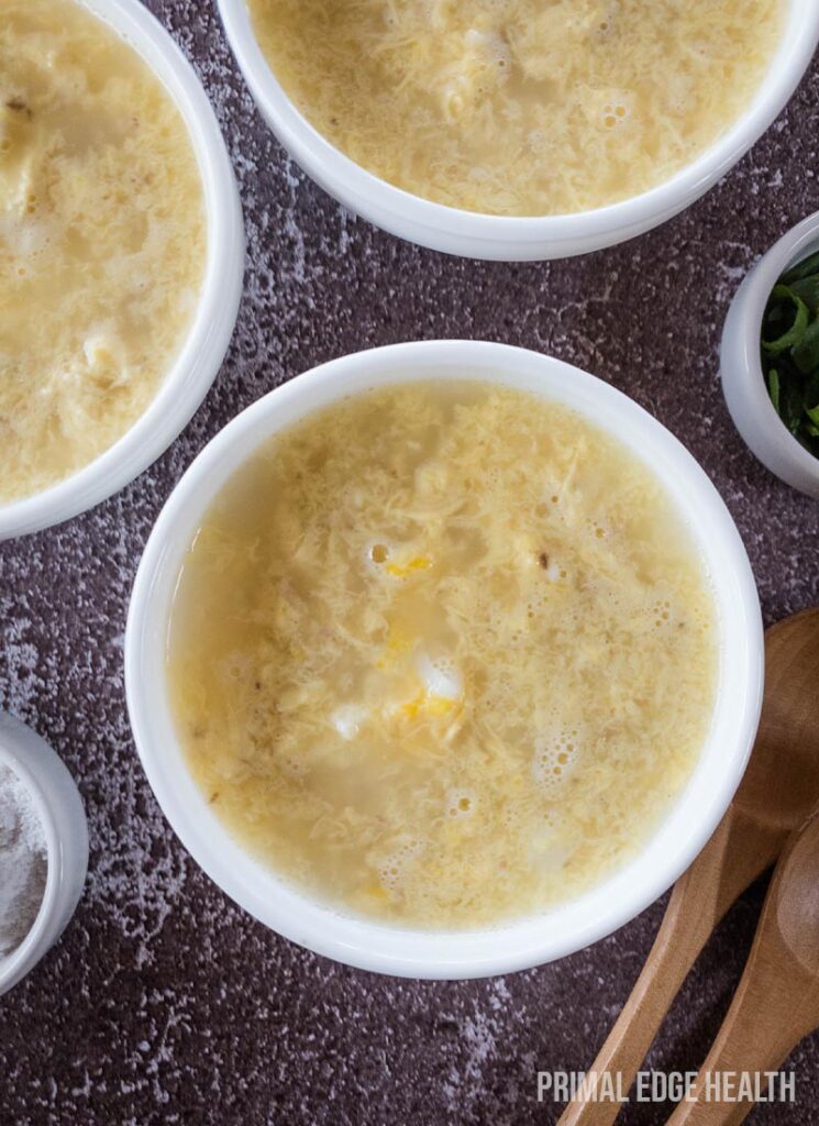 Bowls of egg drop soup on a table.