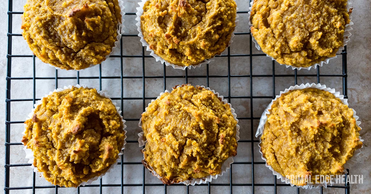 A batch of golden-brown pumpkin muffins on a wire rack.