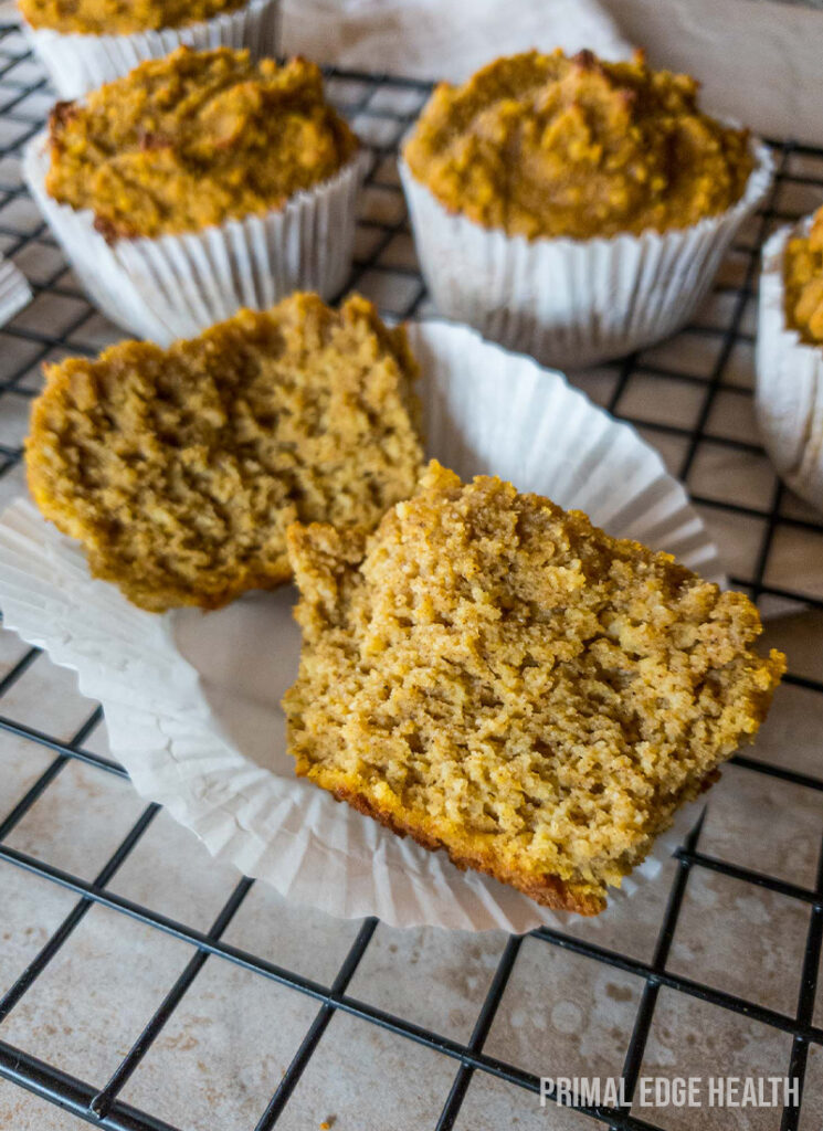 Pumpkin muffin broken in half on a cooling rack.