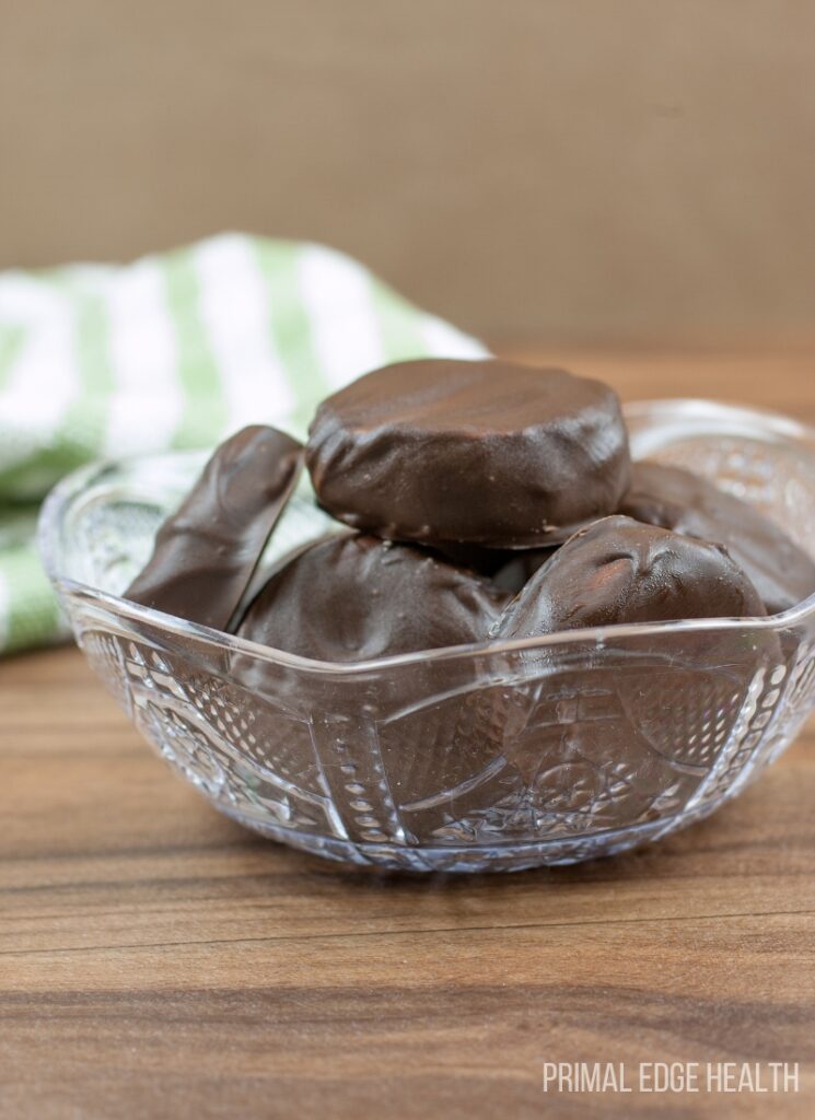 A bowl of peppermint patties on a wooden table.
