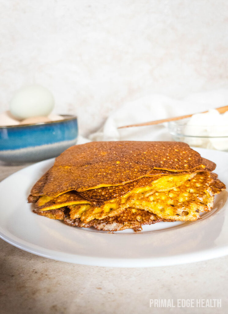 A stack of carnivore pancakes on a white plate.