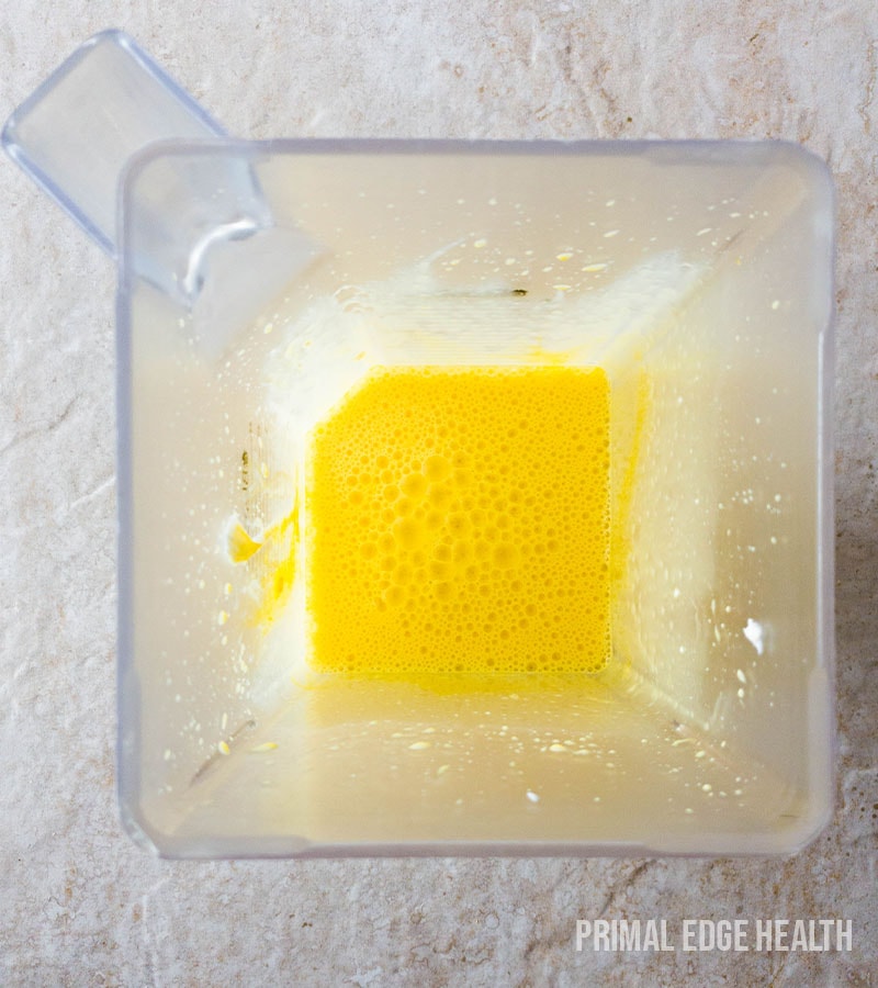 Container with a frothy egg mixture on white surface.
