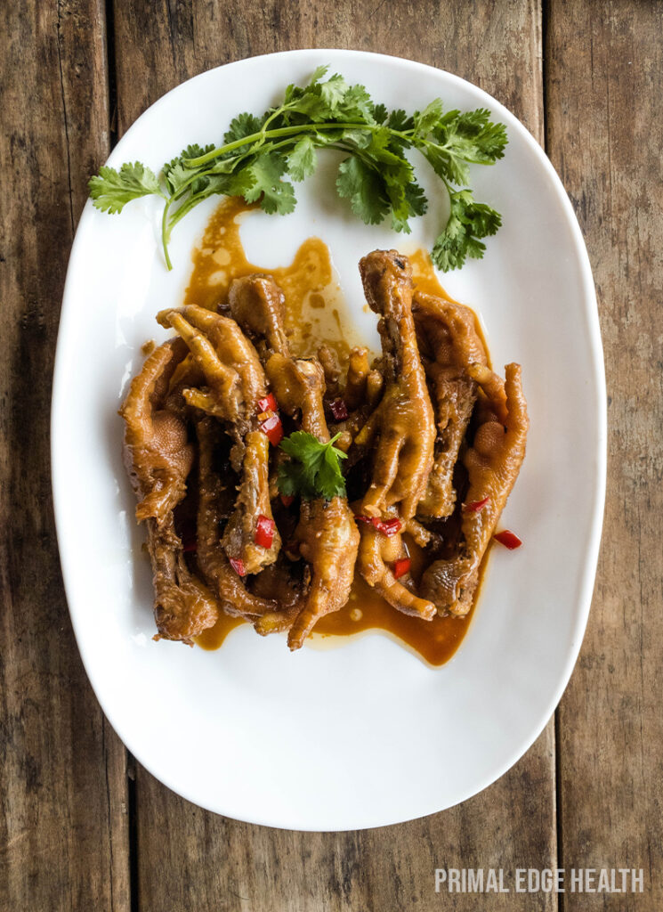 Plated chicken feet adobo with garnish.