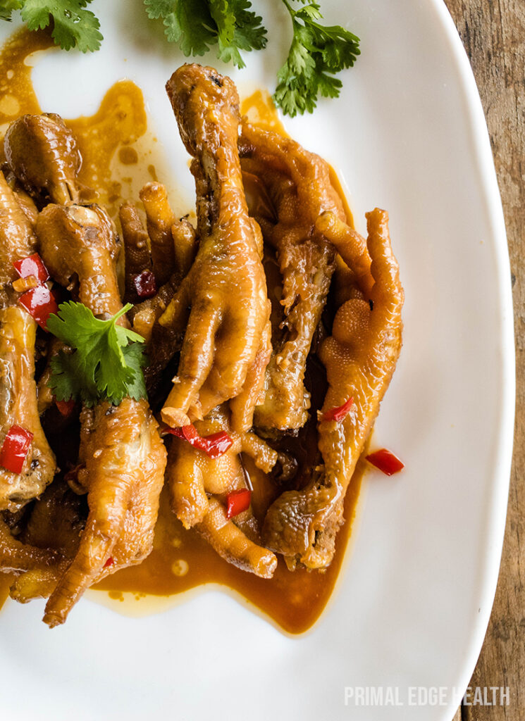 Cooked chicken feet with savory sauce on plate.