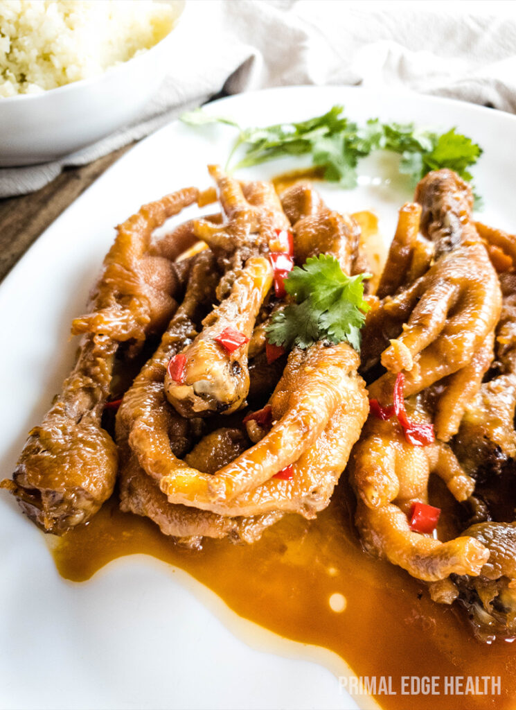 Fried chicken feet in sauce on a white plate.