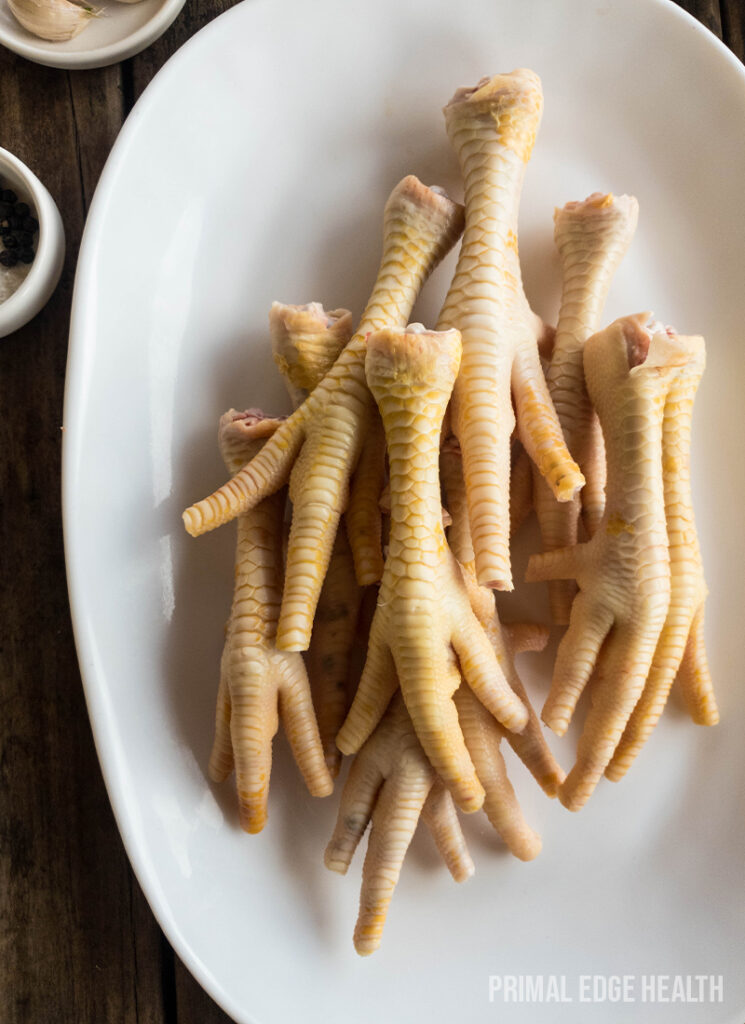 A plate of chicken feet adobo on a wooden table.