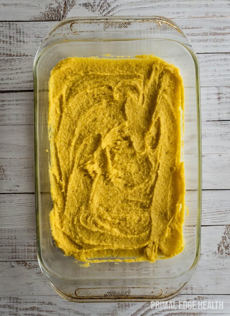 A glass baking dish containing a spread of gooey butter cake.