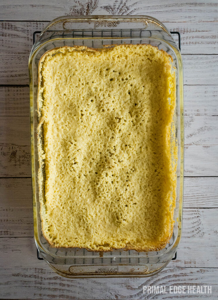 A glass dish of gooey butter cake a on a wooden table.