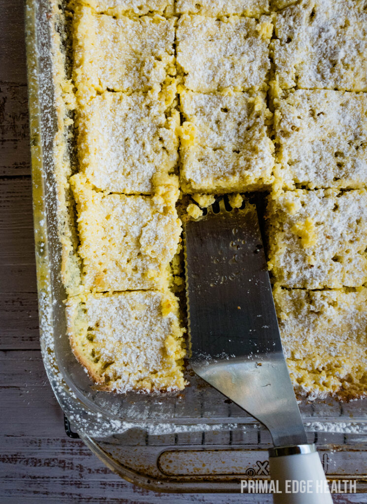 A pan of gooey butter cake and a metal spatula inside.
