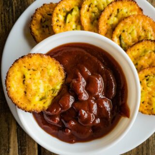 Plate of crisps served with a side of tomato dipping sauce.