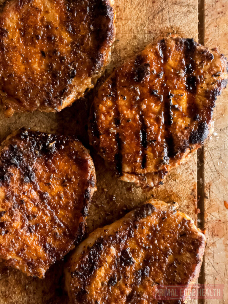 Keto-friendly pork chops on a wooden cutting board.