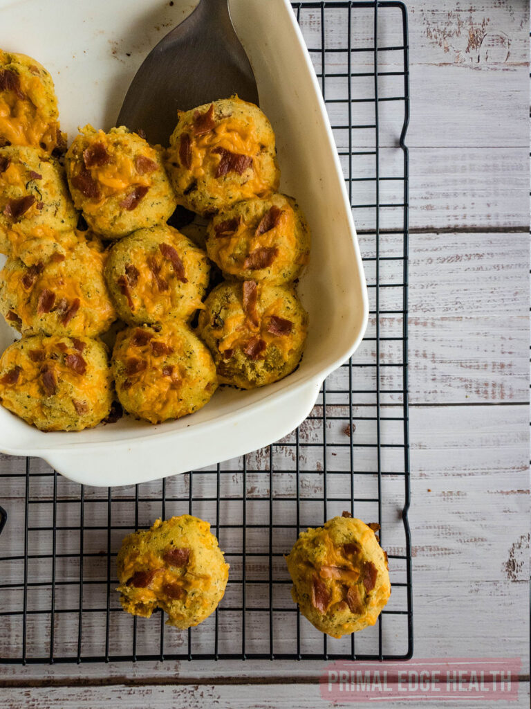 Keto crack biscuits on a cooling rack with a spatula.