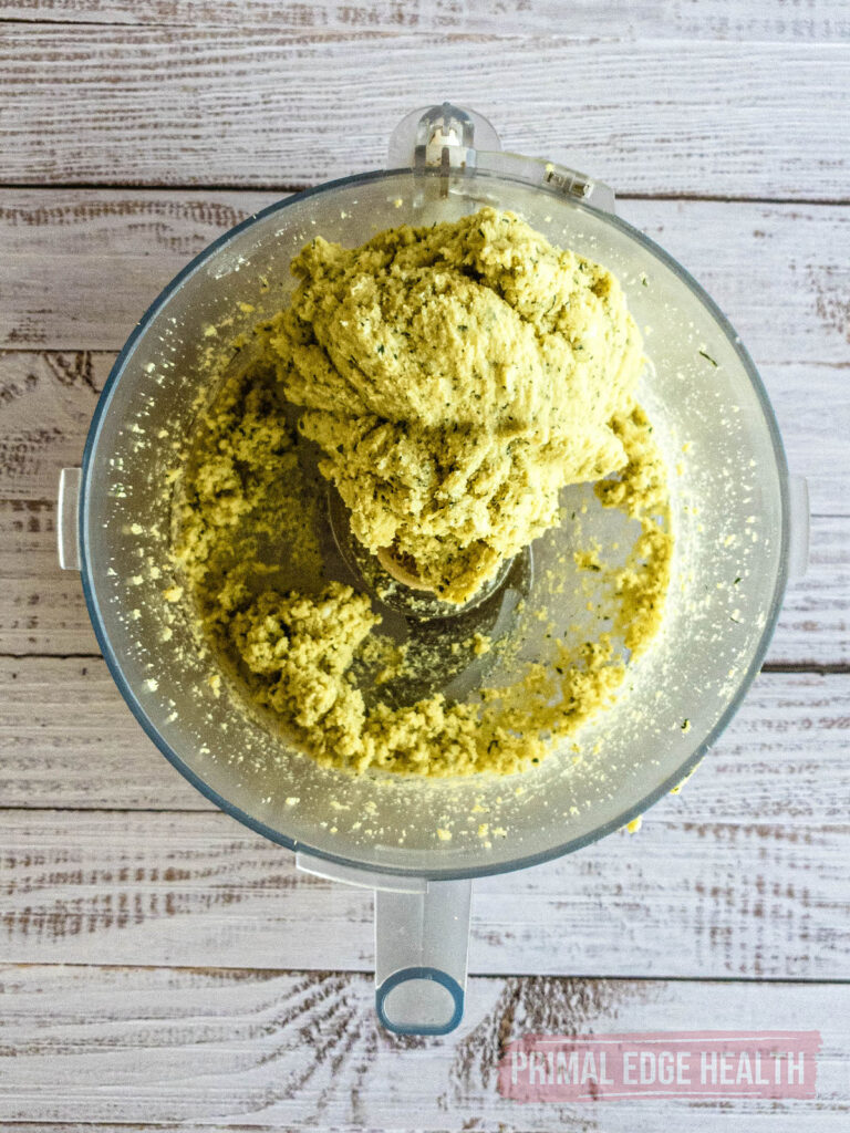 Dough mixture inside a container on a wooden background.