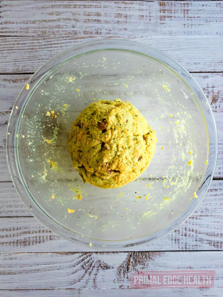 A ball of dough in a glass mixing bowl.