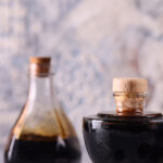 keto balsamic glaze in a glass jar with cork stopper and one larger jar in the background