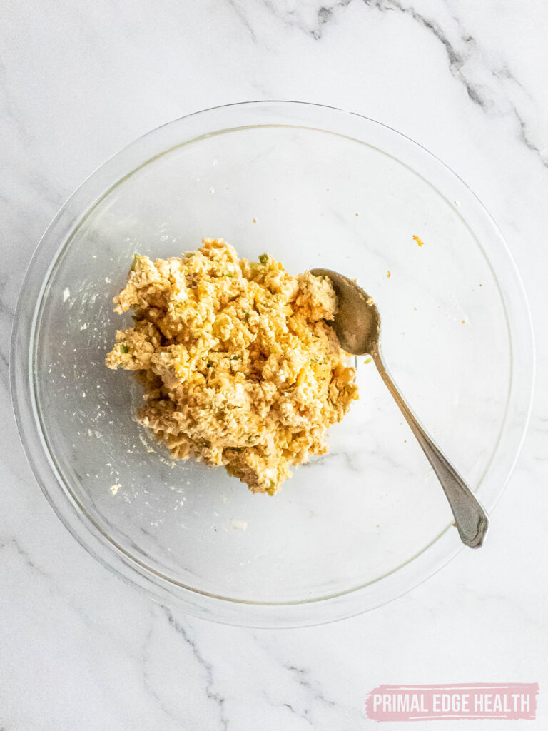 Mixture for cheese ball in glass bowl with spoon.