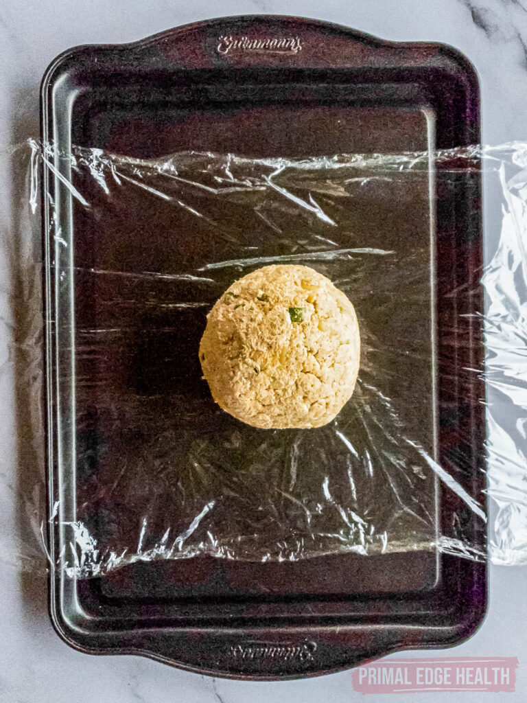 keto cheese ball on plastic wrap for rolling into a ball