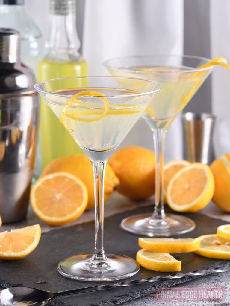 Two keto lemon drop martini cocktails, surrounded bar equipment.