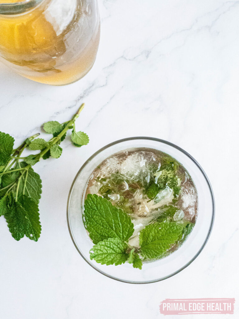 Mint julep recipe in glass with ice and muddled mint.