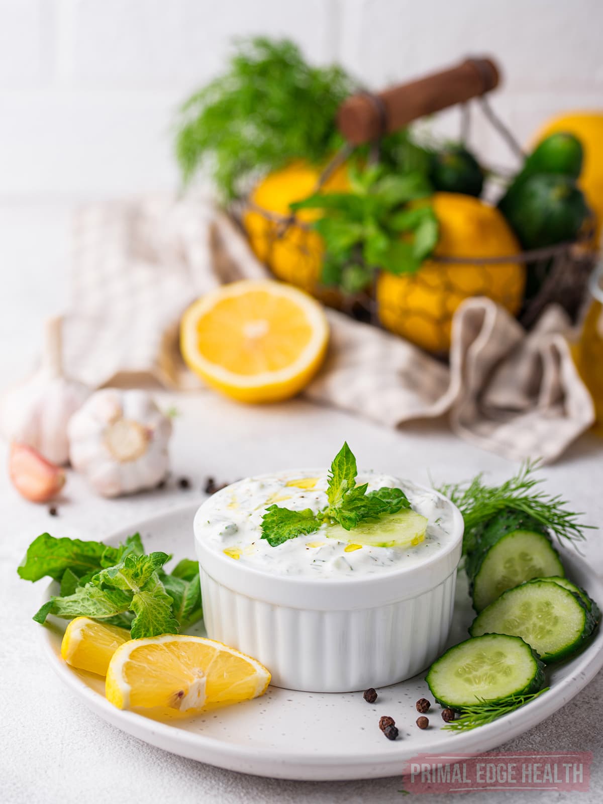 Bowl of keto tzatziki sauce garnished with herbs.