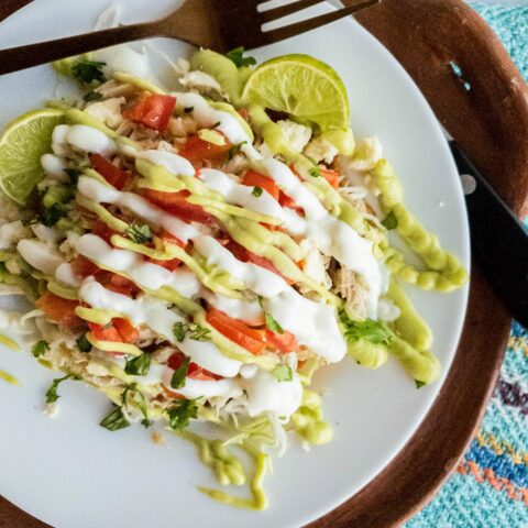 Tostada plated with knife and fork alongside.