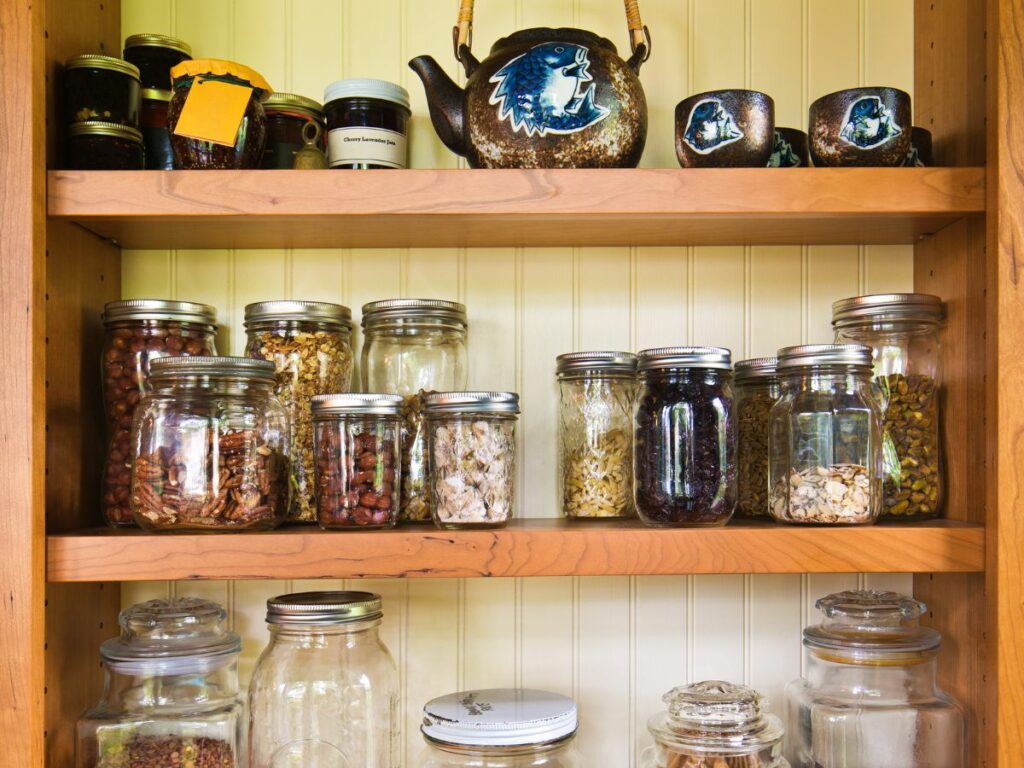 Various jars filled on wooden shelves.