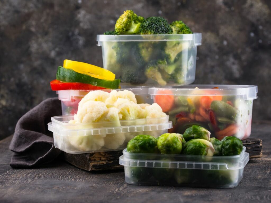 Plastic food storage containers with veggies.