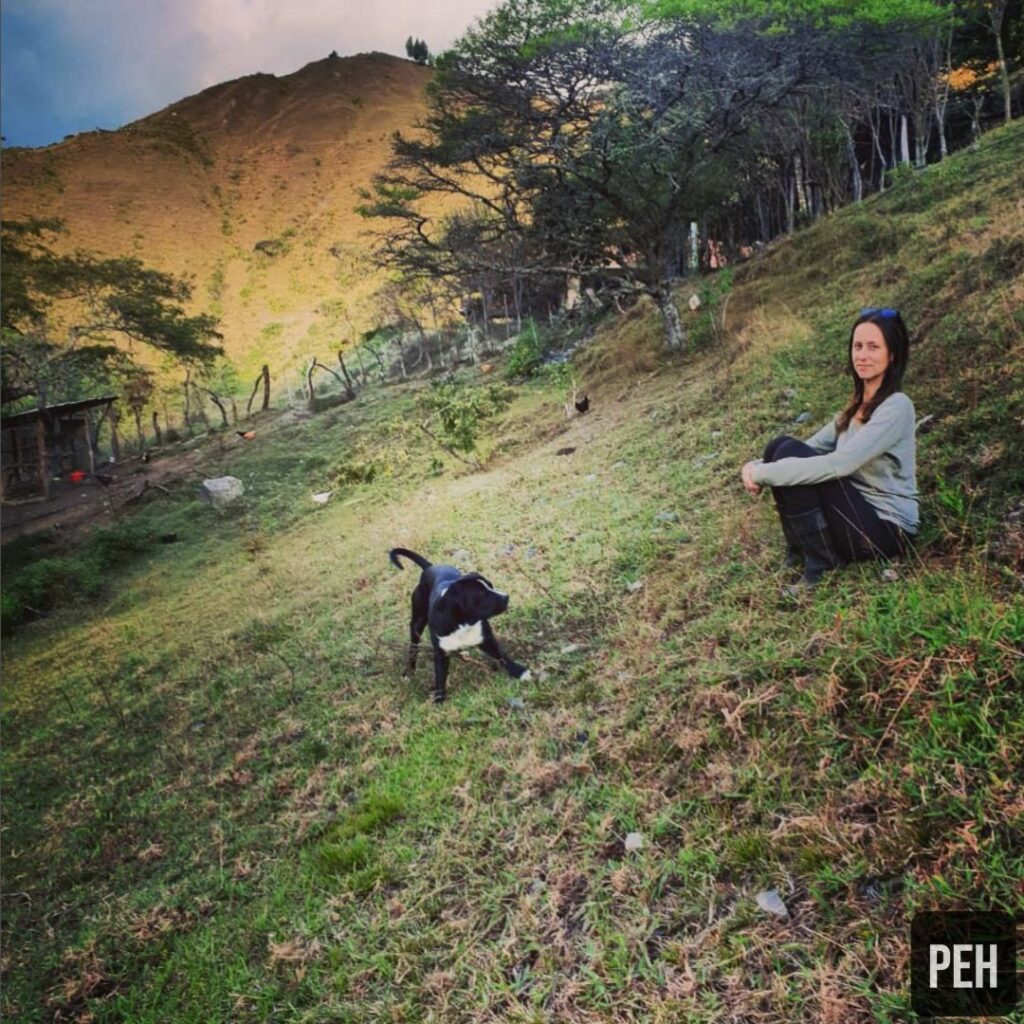 Jessica Haggard on pasture with a dog.