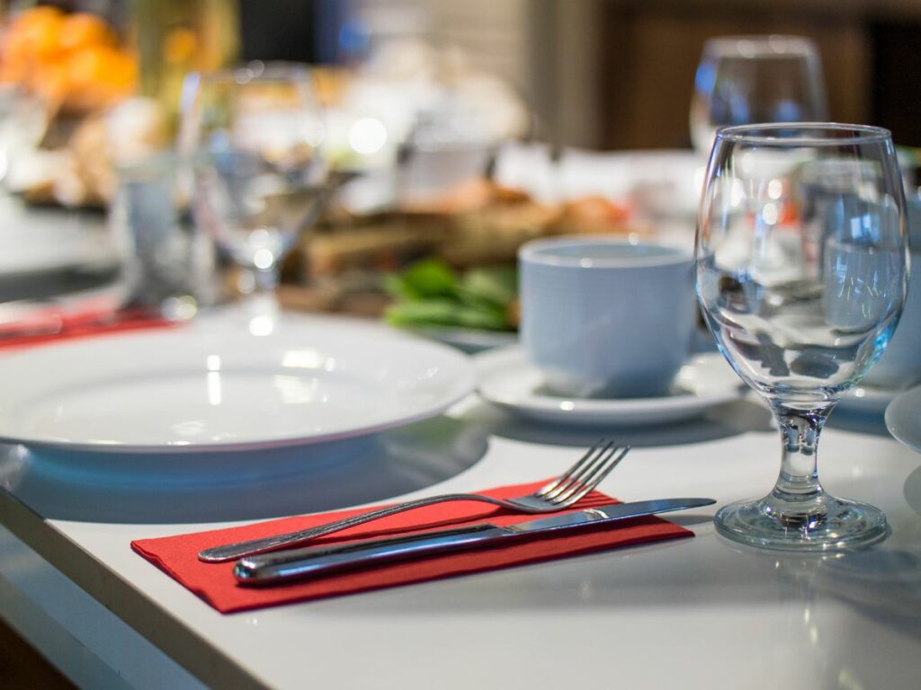 A table setting with silverware and glasses.