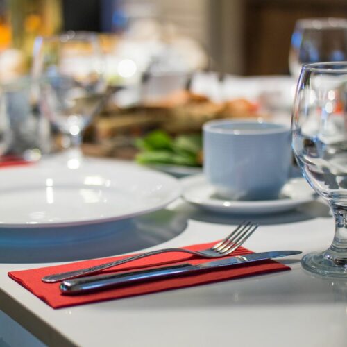 A table setting with silverware and glasses.