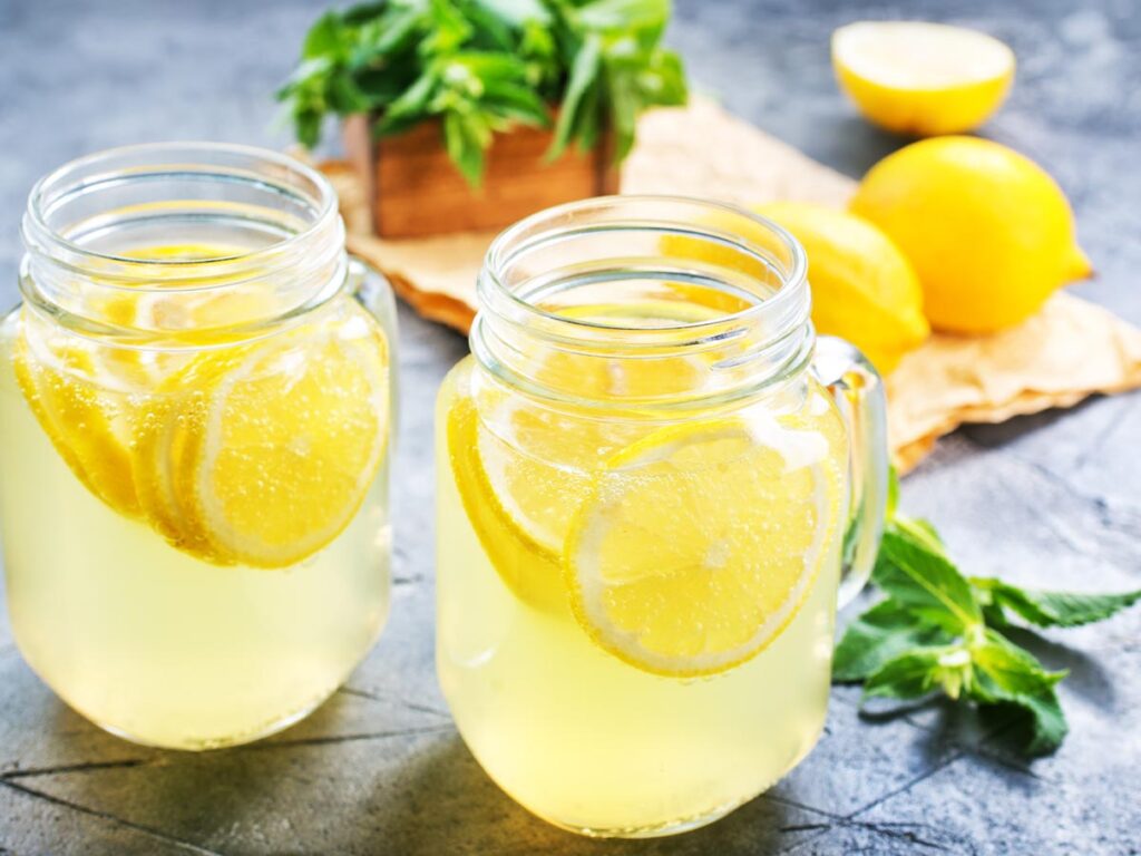 Two glasses of lemonade with lemon slices.