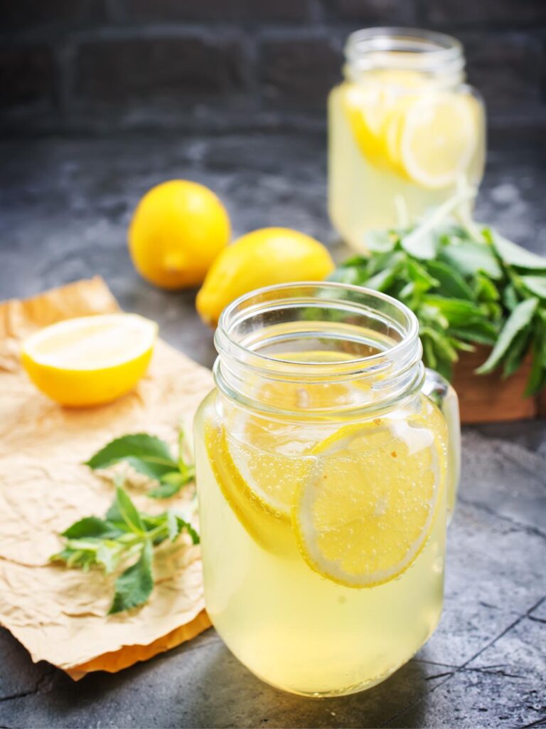 Glass of lemonade on stone surface.